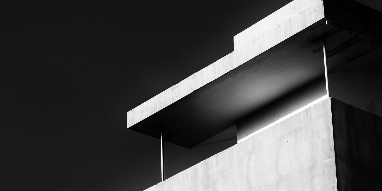 A modern building photographed in black and white, its clean horizontal lines against a pale sky.